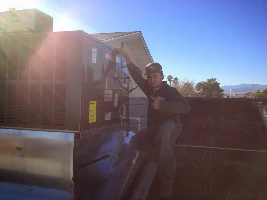 HVAC technician performing Heat Pump Repair on a rooftop unit in Lakemoor