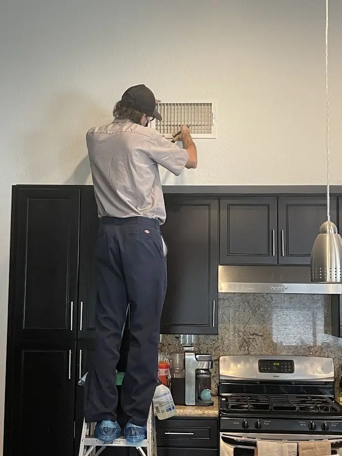 Technician inspecting an air vent during HVAC service in Lakemoor